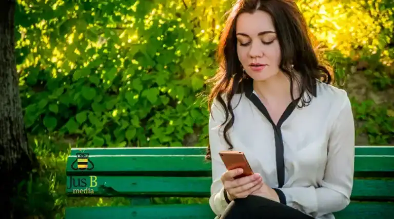 girl sitting on a bench looking at her phone
