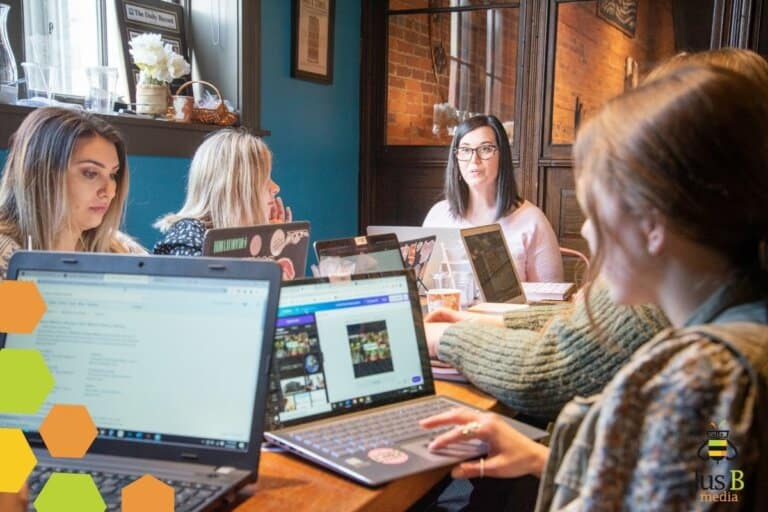 Team of people working at table together with laptops out
