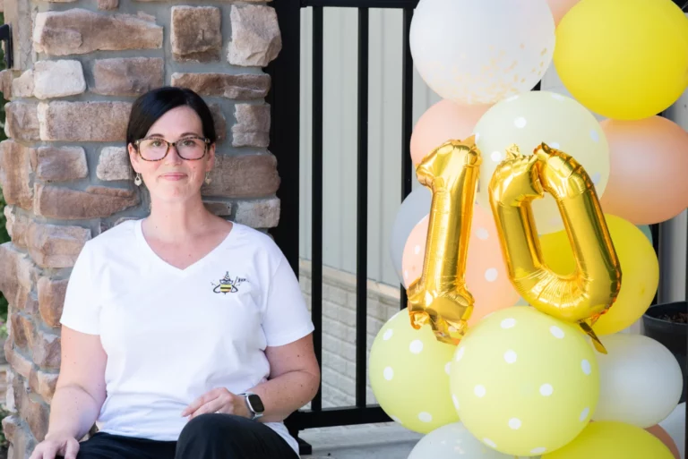 Jessica next to balloons to celebrate 10 years in business